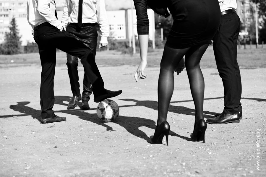 Консультация по стилю / Модельная фотосъемка / Фото девушки на высоких каблуках и трех мужчин моделей у футбольного мяча